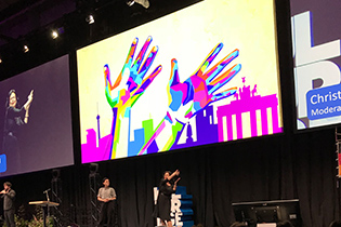 Das bunte Logo zeigt zwei Hände, die Gebärdensprache sprechen. Foto: Bundesfachstelle Barrierefreiheit