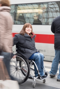Rollstuhlfahrerin auf einem Bahnsteig, ICE im Hintergrund. Foto: Wolfgang Bellwinkel | DGUV