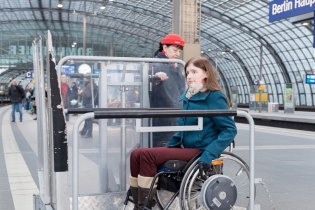 Rollstuhlfahrerin auf einem Bahnsteig am Hauptbahnhof Berlin. Foto: Wolfgang Bellwinkel | DGUV