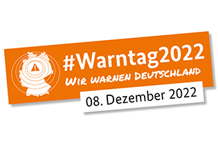 Auf orangefarbenem Hintergrund ist eine Deutschlandkarte zu sehen und es steht der Text: #Warntag2022 -Wir warnen Deutschland - 08. Dezember 2022